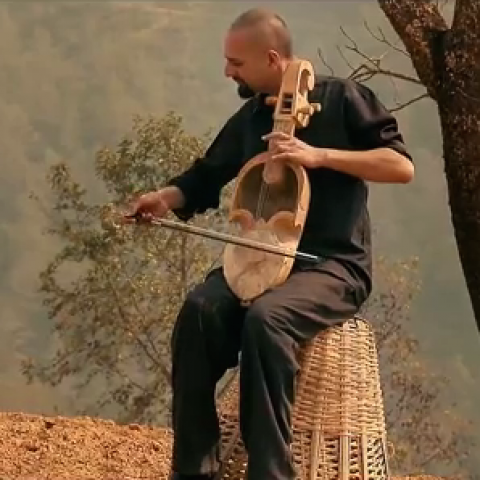 Man playing wooden string instrument